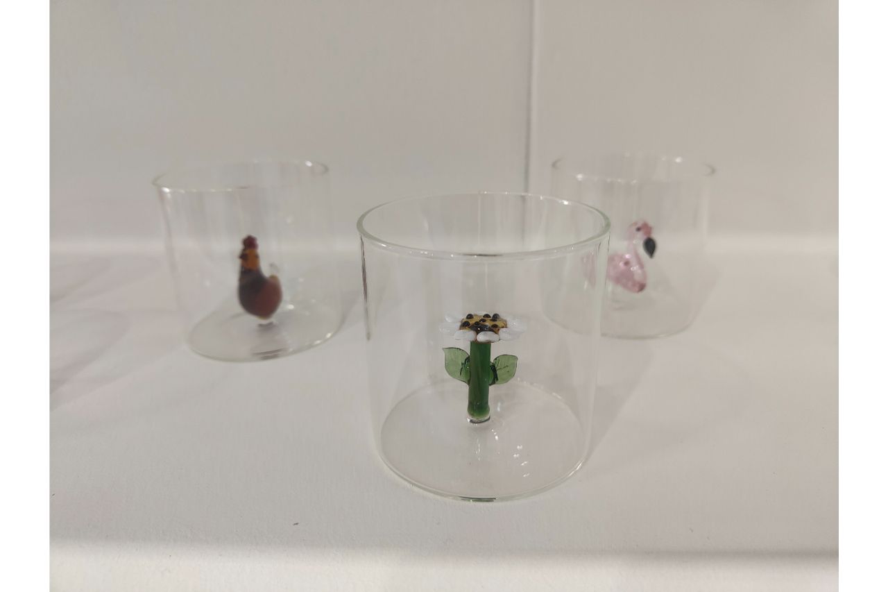 <p>Mercati inserisce nei bicchieri e nelle caraffe piccole “sculture” colorate in un gioco di rimandi dove il vetro diventa contenitore e contenuto</p>
